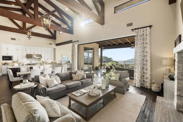 a large white kitchen with a large window and stainless steel appliances