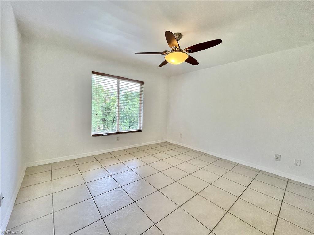 5470 16th Place Southwest, Unit 107 Naples, FL 34116 - Photo 14 of 31 an empty room with windows and fan