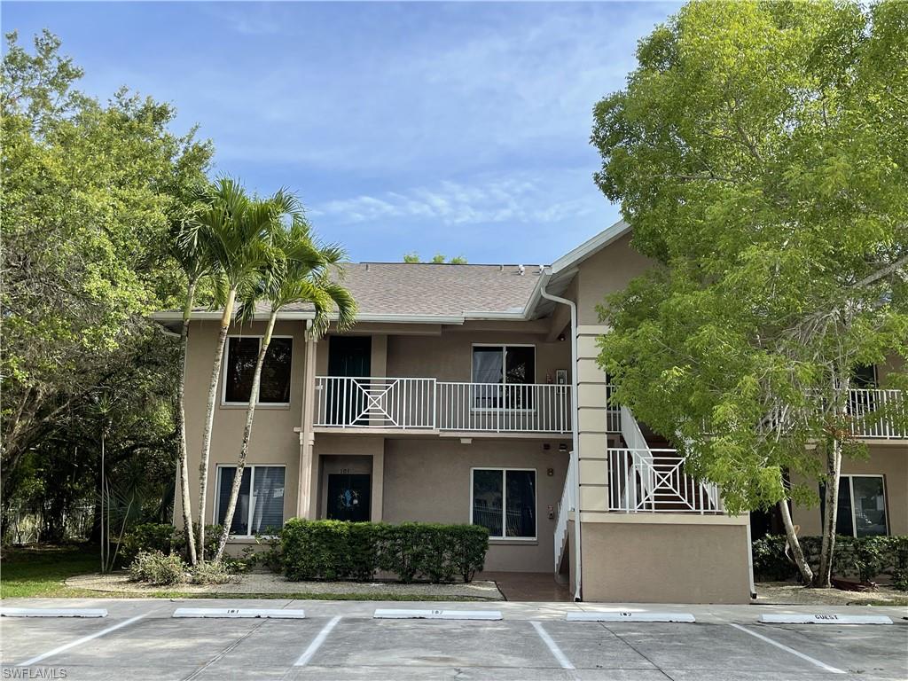 5470 16th Place Southwest, Unit 107 Naples, FL 34116 - Photo 25 of 31 a front view of a house with a yard