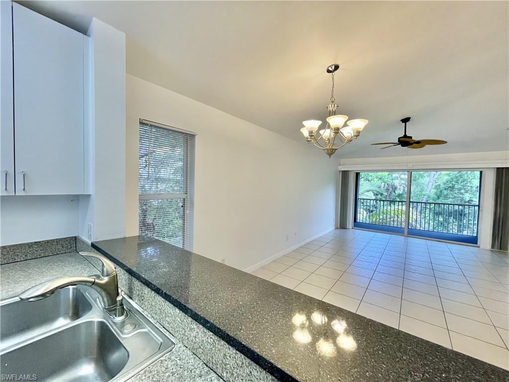 5470 16th Place Southwest, Unit 107 Naples, FL 34116 - Photo 4 of 31 a view of a kitchen with a sink cabinetry and chandelier