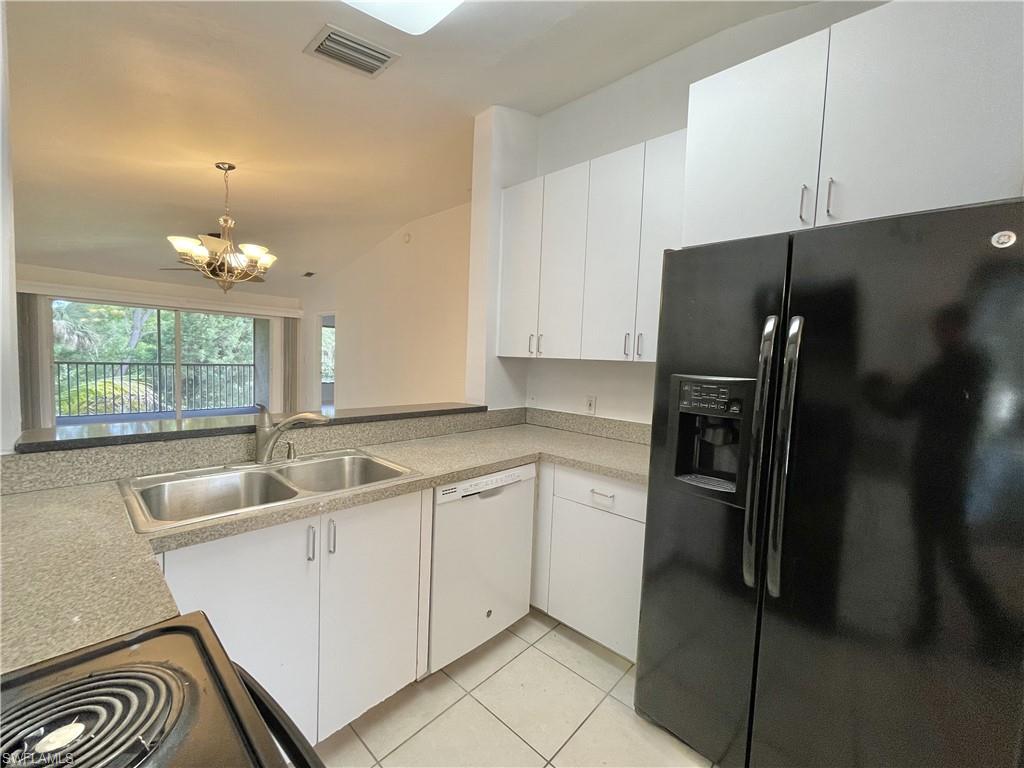 5470 16th Place Southwest, Unit 107 Naples, FL 34116 - Photo 7 of 31 a kitchen with a sink cabinets and refrigerator