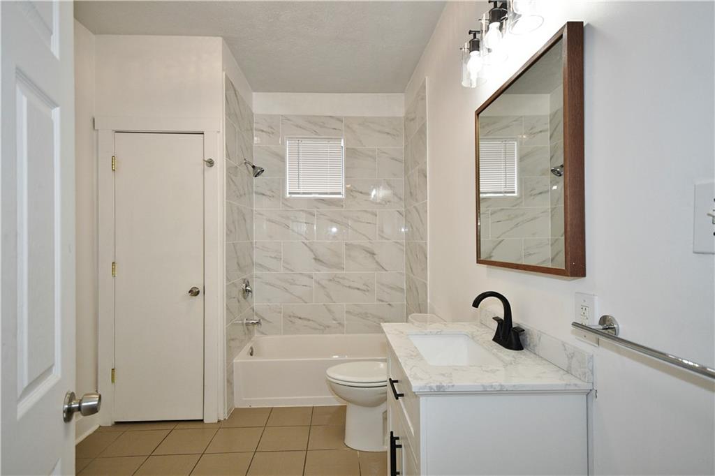 4627 Plummer Street Pittsburgh, PA 15201 - Photo 17 of 29 a bathroom with a granite countertop toilet a sink and bathtub