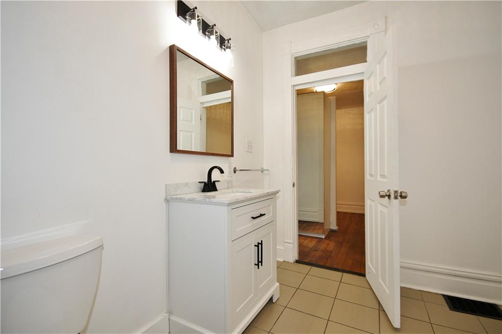 4627 Plummer Street Pittsburgh, PA 15201 - Photo 18 of 29 a spacious bathroom with a double vanity sink a mirror and a toilet