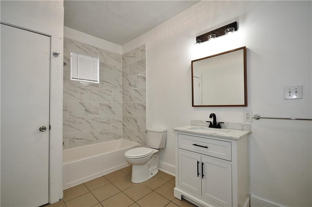 4627 Plummer Street Pittsburgh, PA 15201 - Photo 19 of 29 a bathroom with a toilet sink vanity tub and mirror