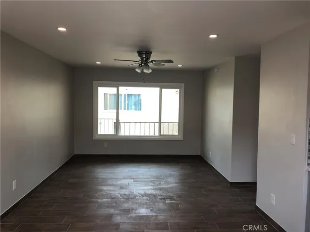 an empty room with a window and a ceiling fan