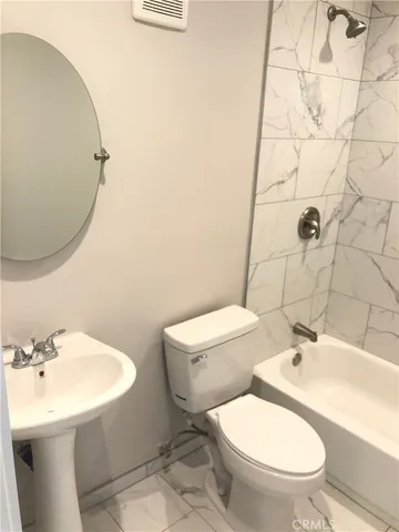 a white toilet sitting next to a bathroom sink
