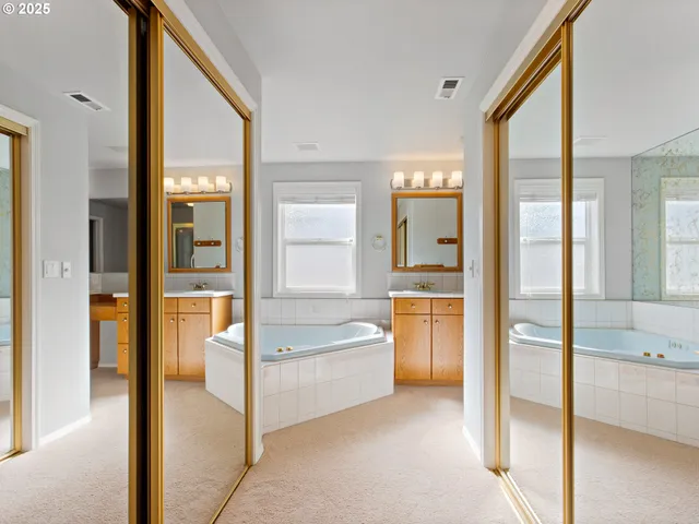 a bathroom with a tub sink and mirror