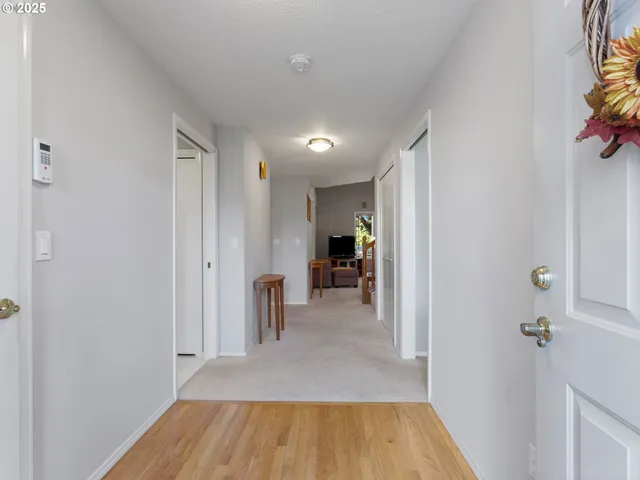 a view of a hallway with wooden floor and furniture