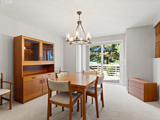 a dining room with furniture a chandelier and window