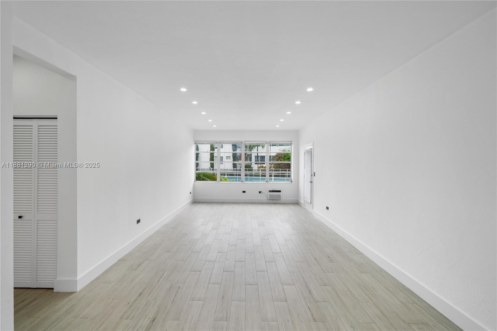 4710 Pine Tree Drive, Unit 31 Miami Beach, FL 33140 - Photo 11 of 25 a view of an empty room with wooden floor and windows