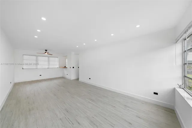 an empty room with white walls and windows