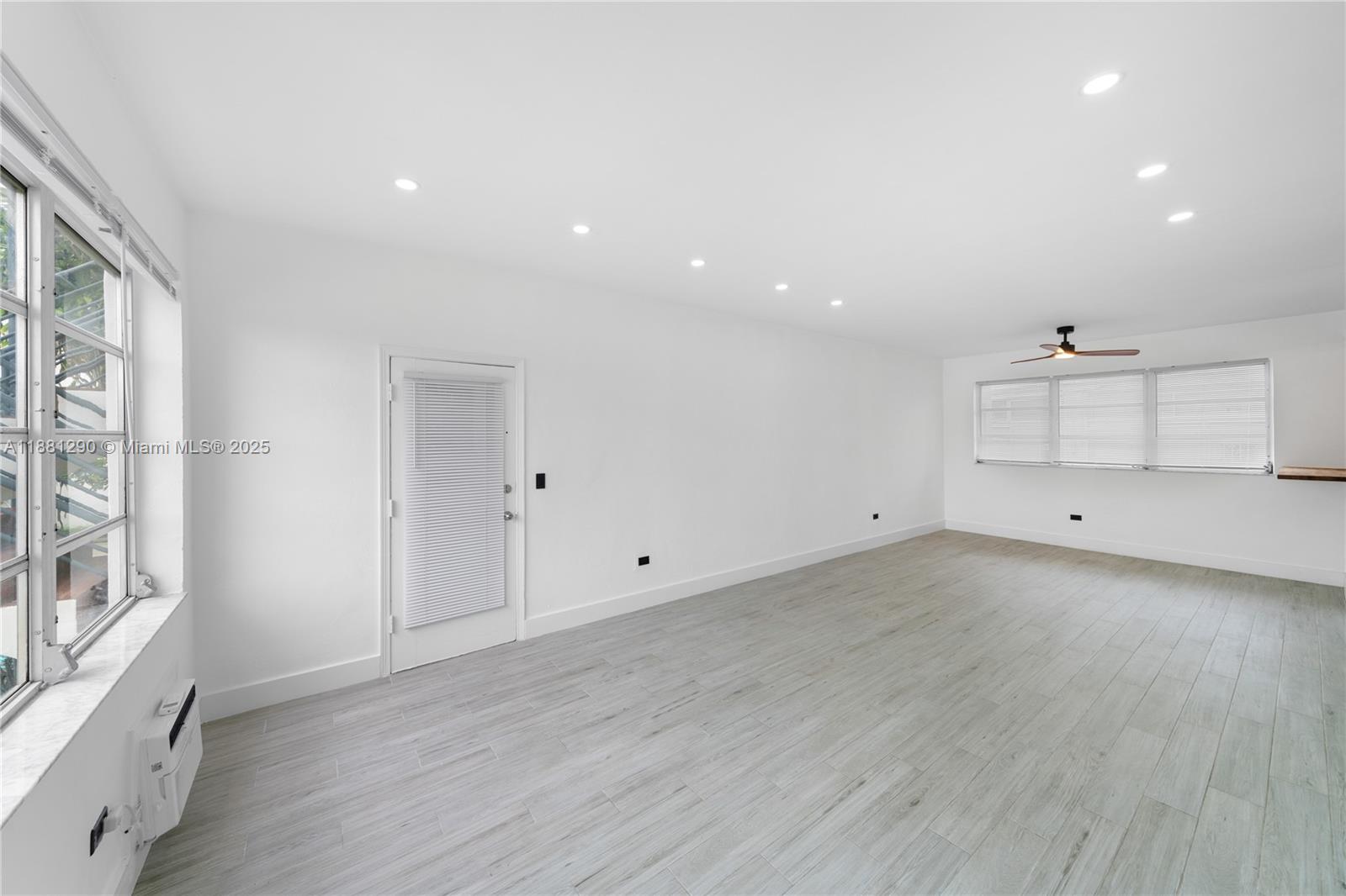 4710 Pine Tree Drive, Unit 31 Miami Beach, FL 33140 - Photo 13 of 25 an empty room with wooden floor and windows