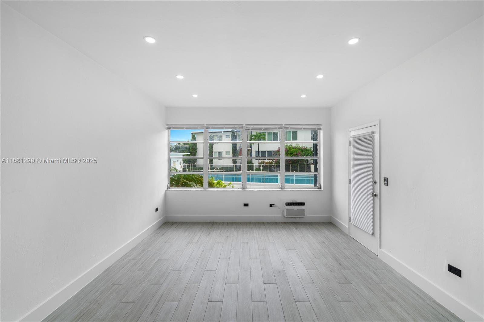 4710 Pine Tree Drive, Unit 31 Miami Beach, FL 33140 - Photo 14 of 25 a view of an empty room with wooden floor and a window