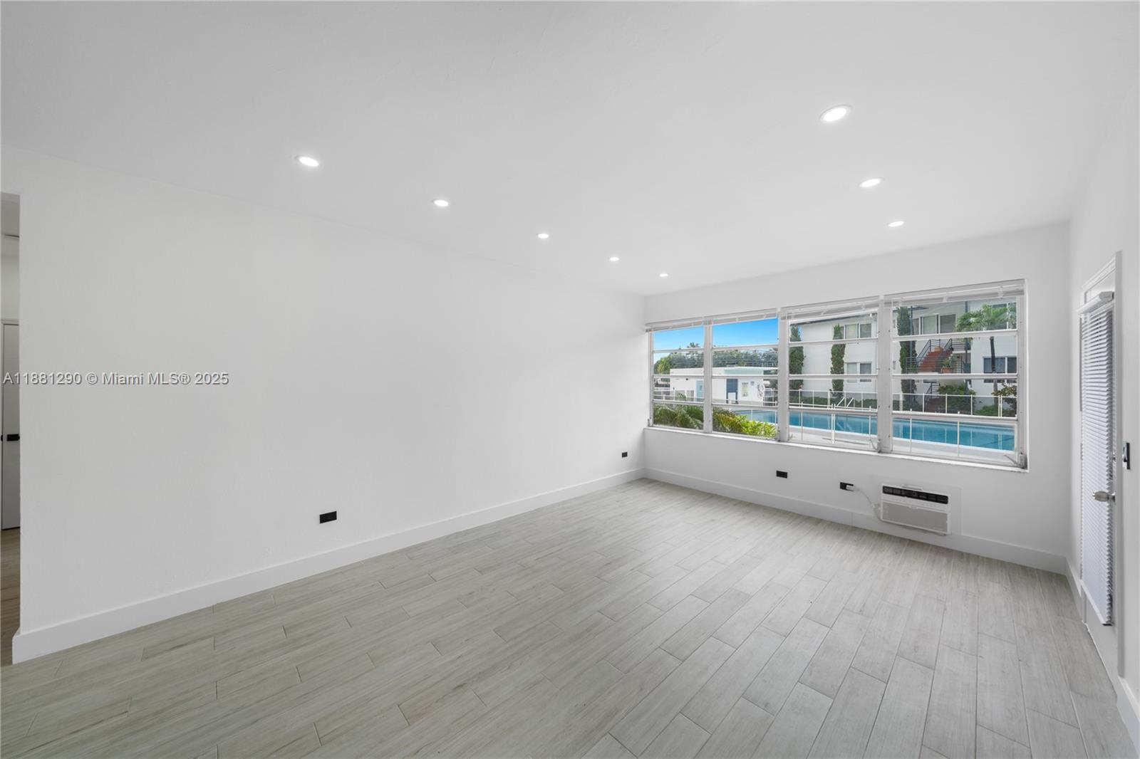 4710 Pine Tree Drive, Unit 31 Miami Beach, FL 33140 - Photo 15 of 25 a view of an empty room with wooden floor and windows