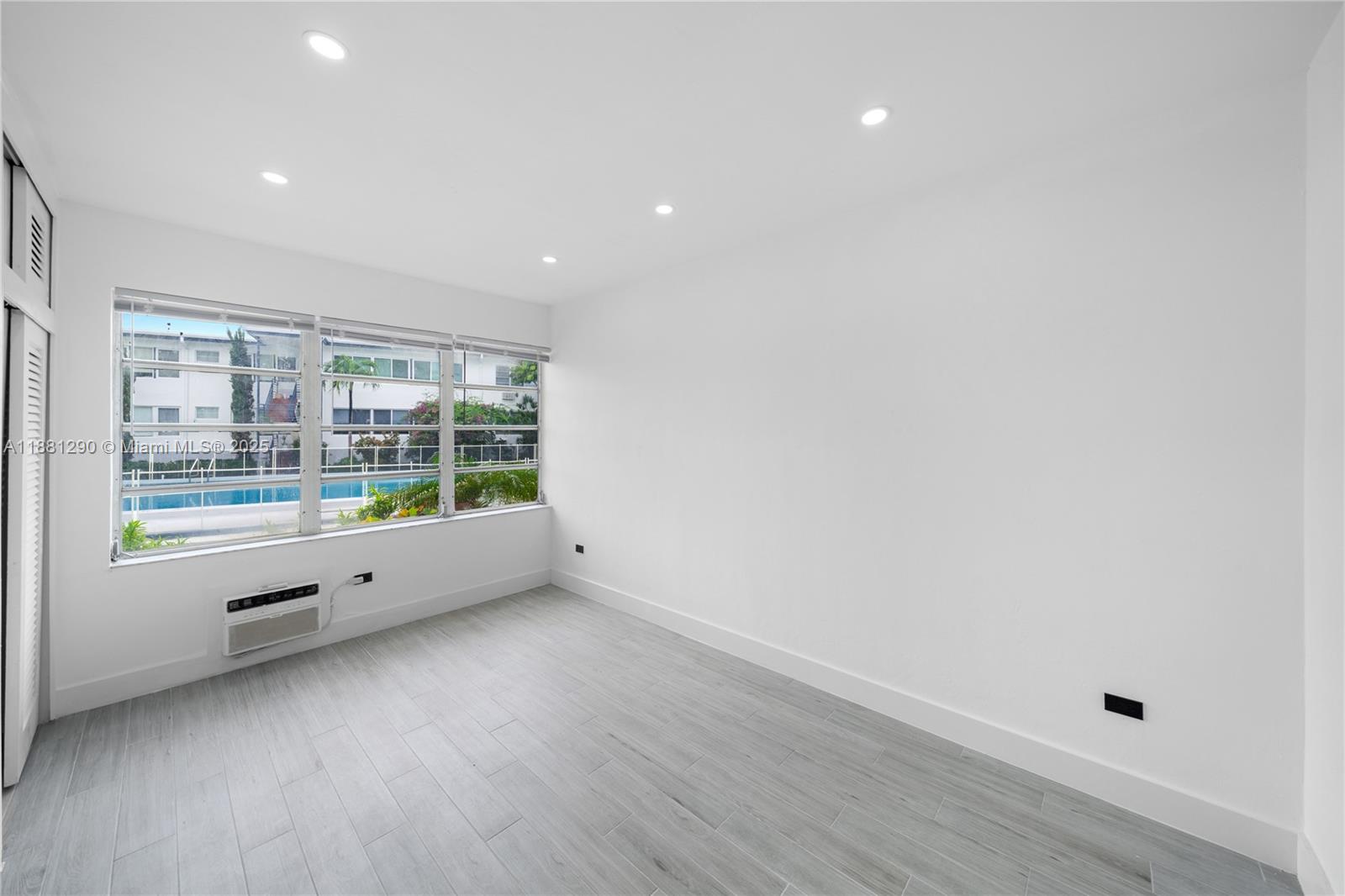 4710 Pine Tree Drive, Unit 31 Miami Beach, FL 33140 - Photo 23 of 25 a view of an empty room with wooden floor and a window