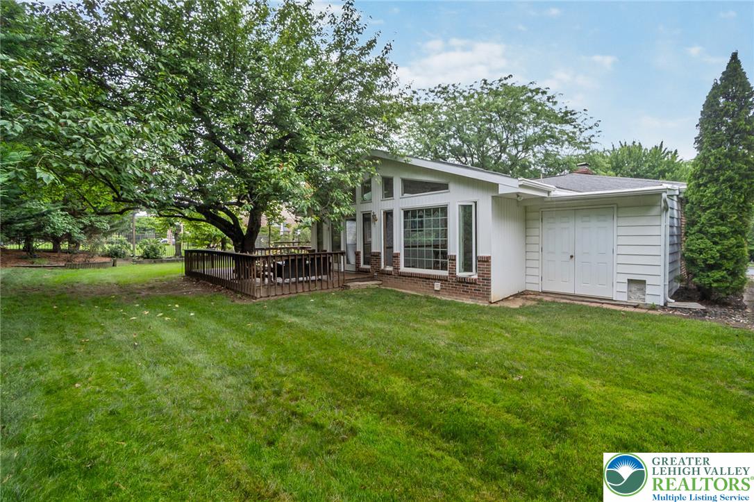 1328 Russett Road Allentown, PA 18104 - Photo 44 of 46 Mature trees shade a private backyard, highlighting a secluded deck perfect for relaxation.