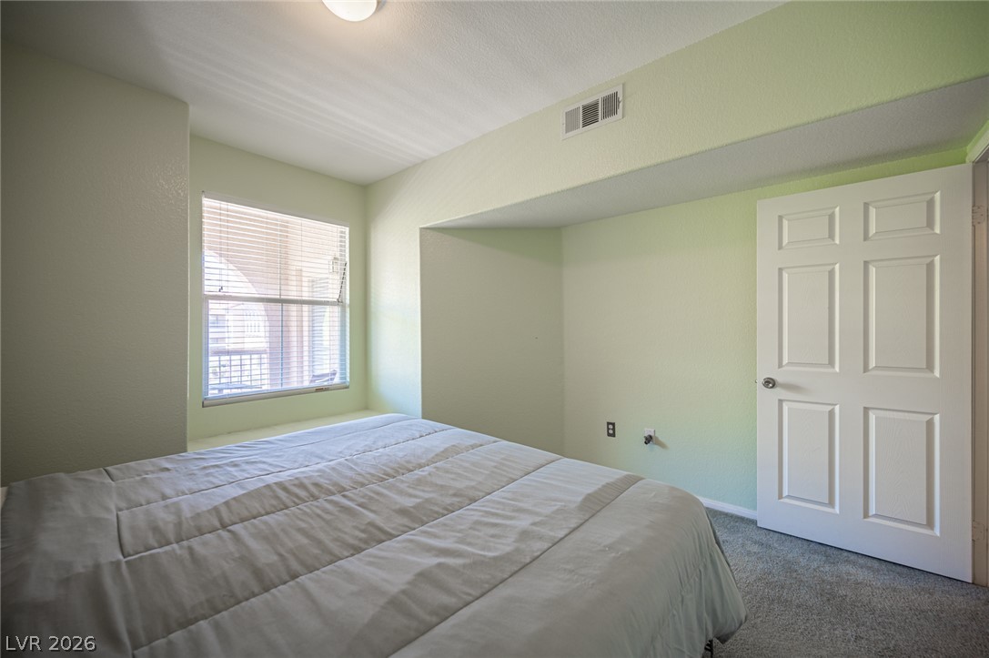10550 West Alexander Road, Unit 2014 Las Vegas, NV 89129 - Photo 22 of 35 A well-lit sleeping area offers carpet flooring and a multi-pane window.