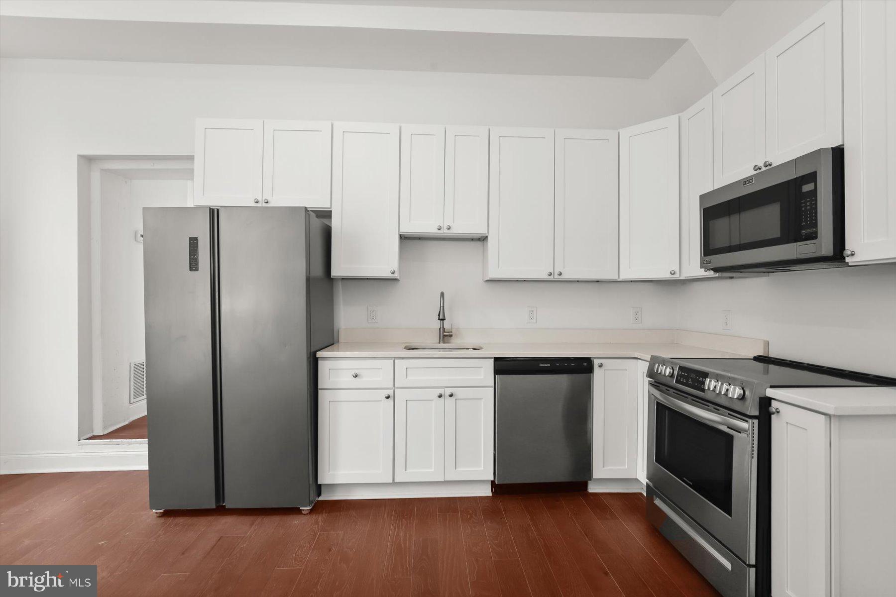 14 East Read Street Baltimore, MD 21202 - Photo 18 of 61 a kitchen with stainless steel appliances granite countertop cabinets and wooden floor