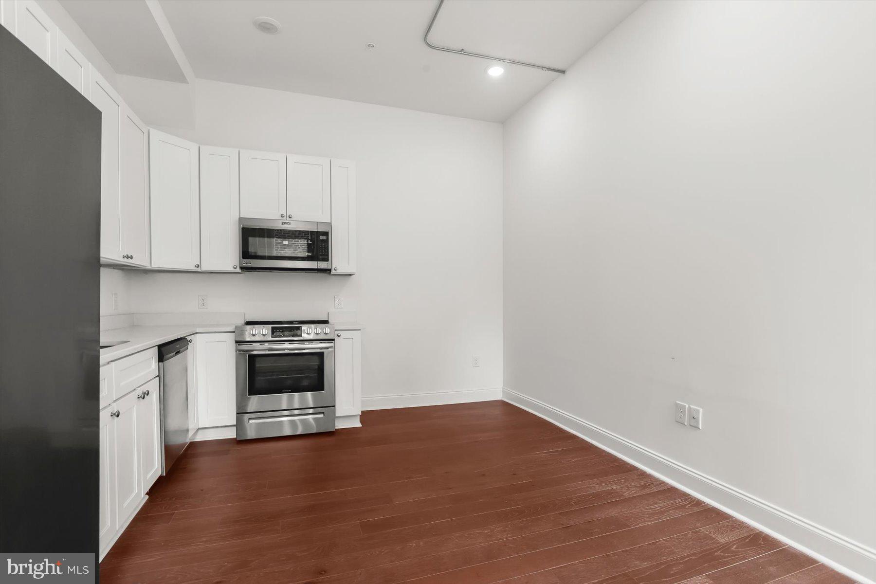 14 East Read Street Baltimore, MD 21202 - Photo 19 of 61 a kitchen with stainless steel appliances a stove top oven a sink and a microwave