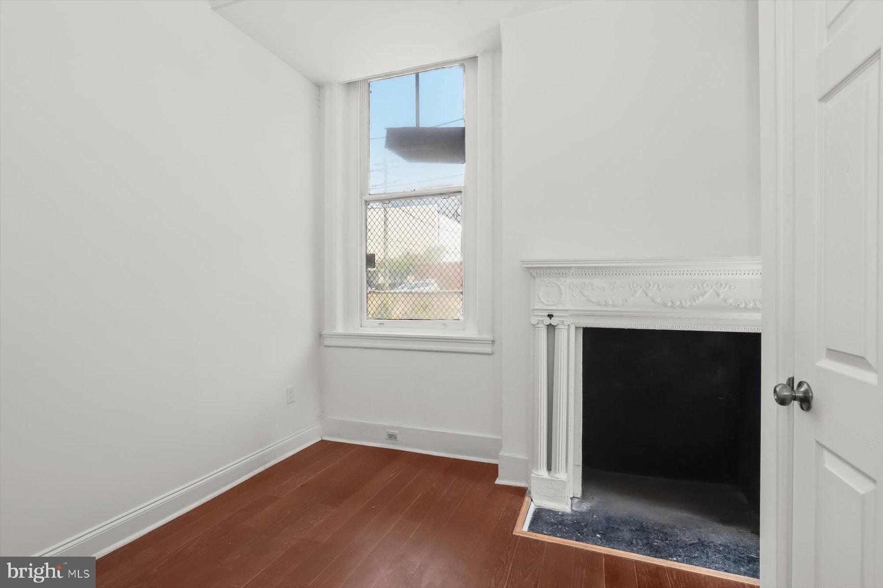 14 East Read Street Baltimore, MD 21202 - Photo 22 of 61 a view of an empty room with wooden floor and a window