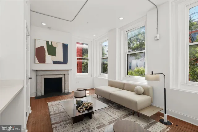 a kitchen with stainless steel appliances granite countertop a sink a stove a refrigerator and white cabinets