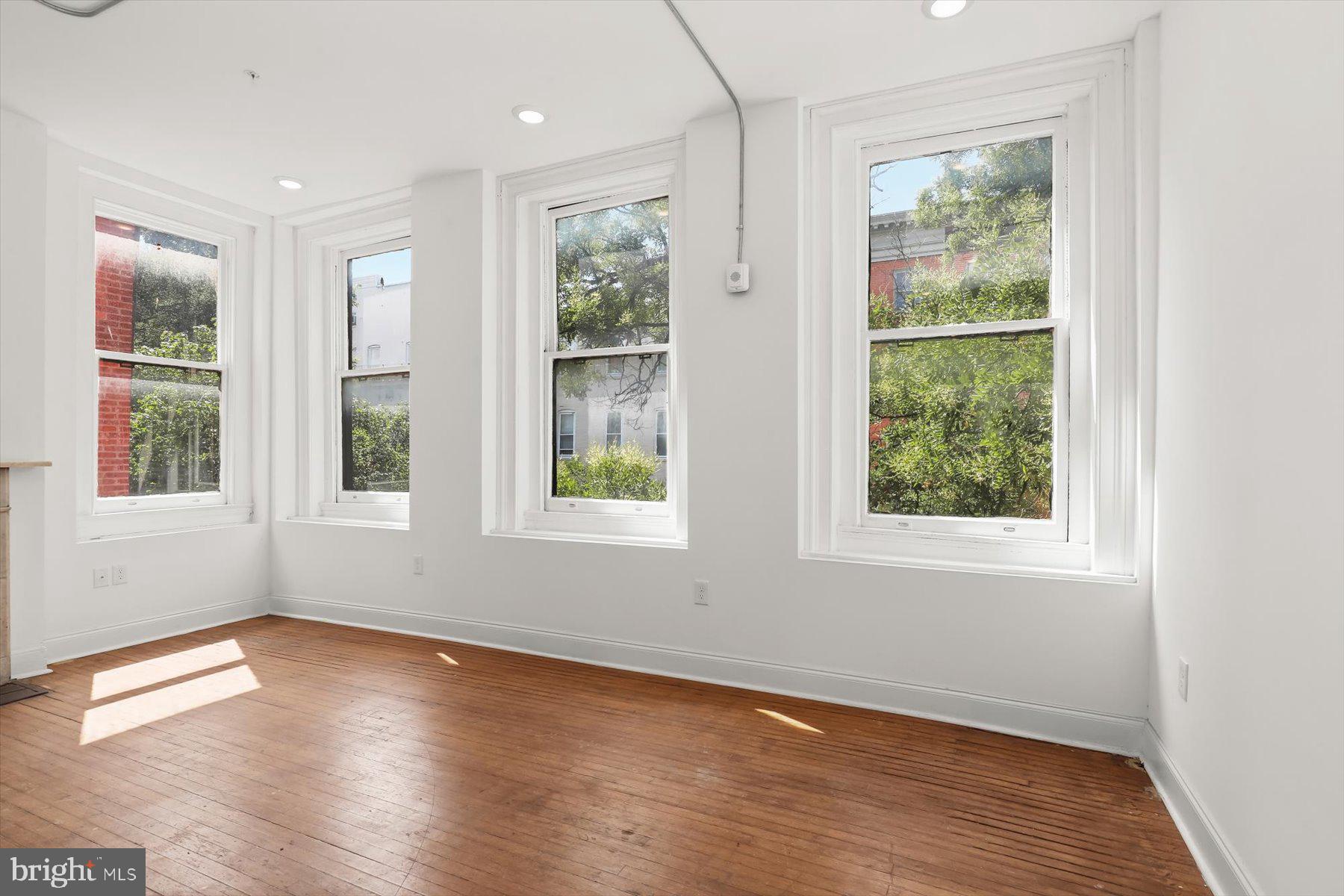 14 East Read Street Baltimore, MD 21202 - Photo 28 of 61 an empty room with wooden floor and windows