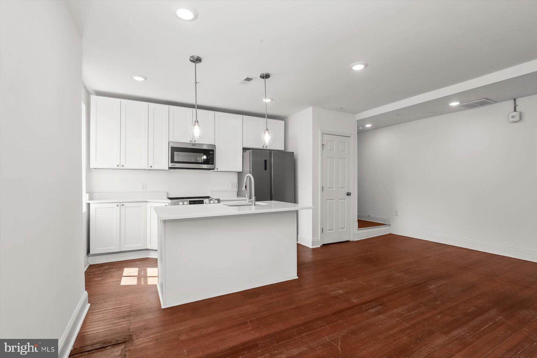 14 East Read Street Baltimore, MD 21202 - Photo 34 of 61 a kitchen with stainless steel appliances granite countertop a sink a stove a refrigerator and white cabinets