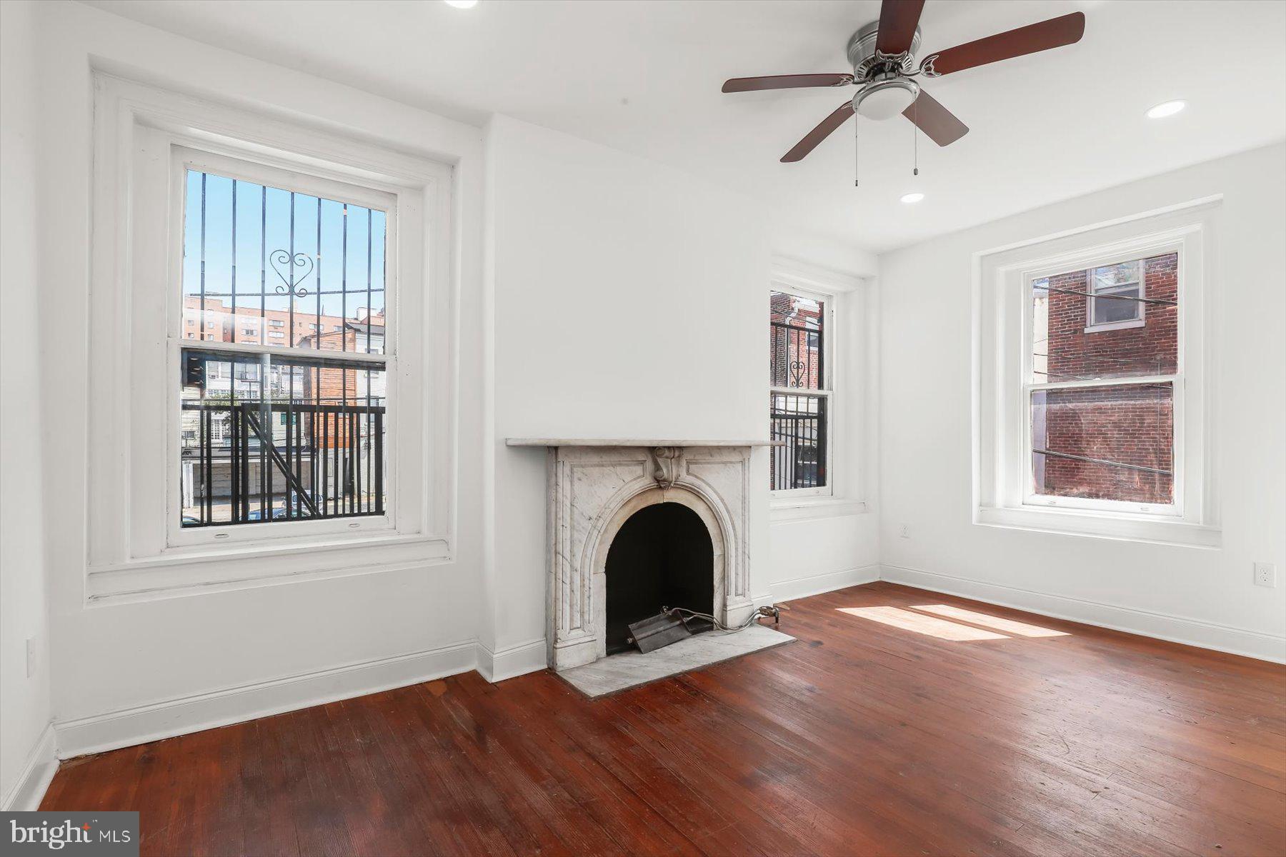 14 East Read Street Baltimore, MD 21202 - Photo 35 of 61 a view of a livingroom with a fireplace wooden floor and windows