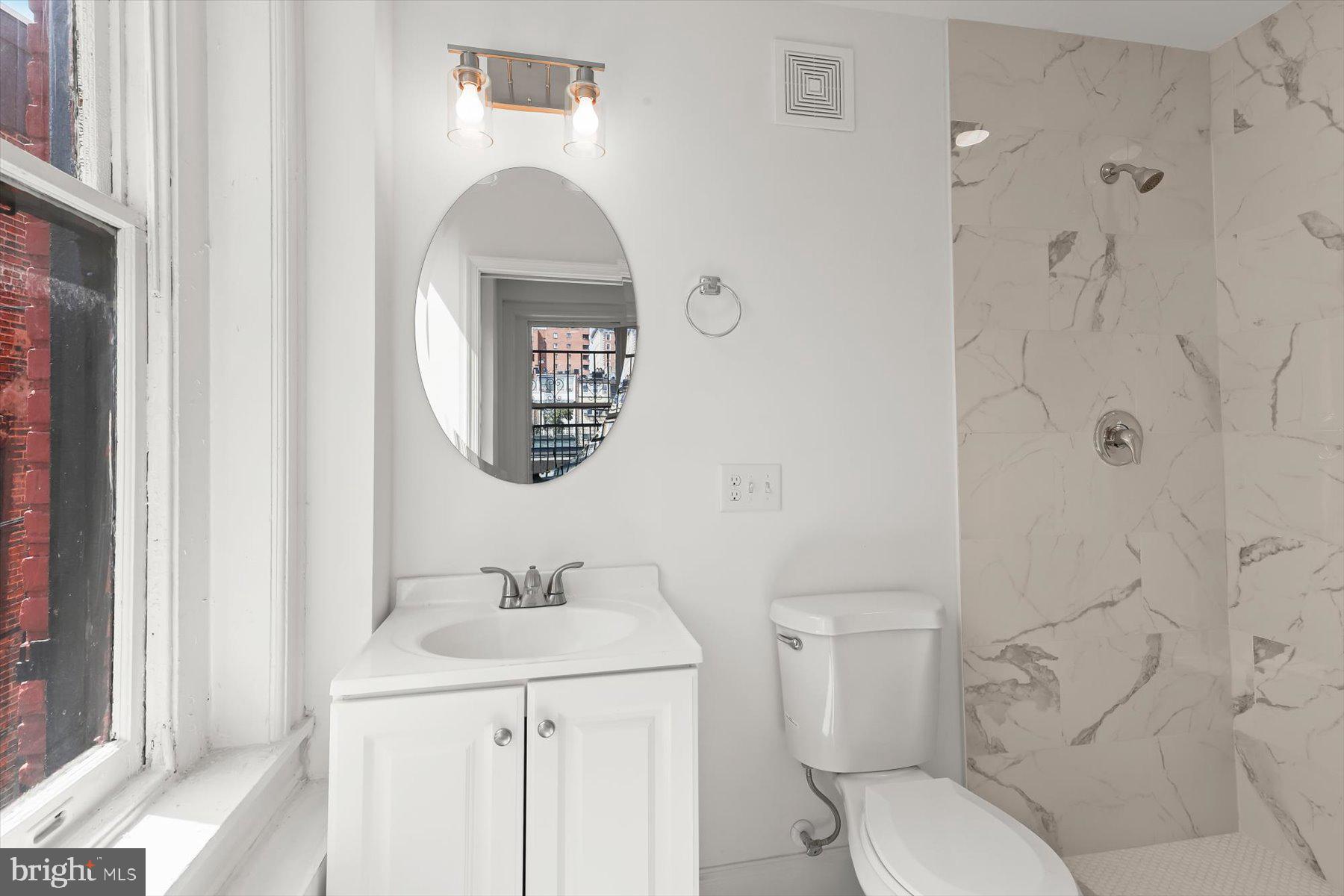 14 East Read Street Baltimore, MD 21202 - Photo 37 of 61 a bathroom with a toilet sink and mirror