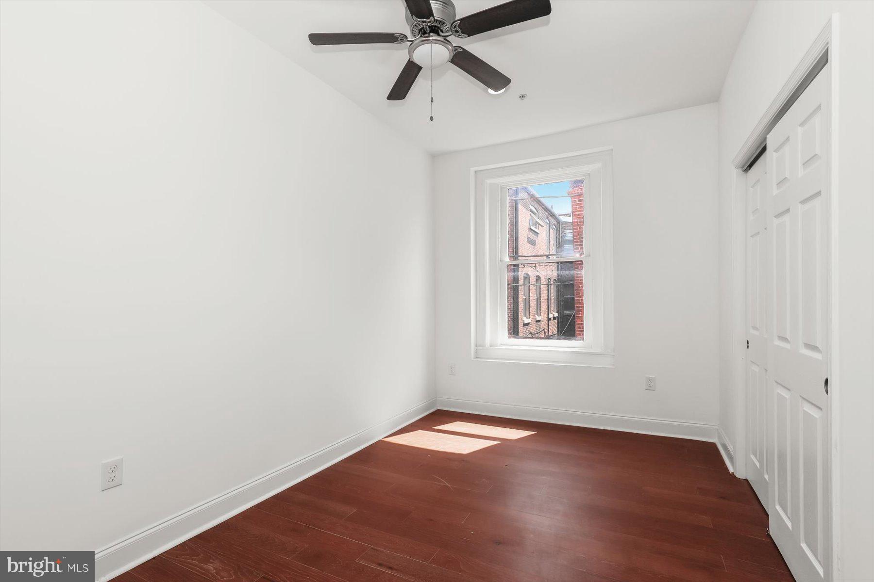 14 East Read Street Baltimore, MD 21202 - Photo 38 of 61 a view of an empty room with wooden floor and a window