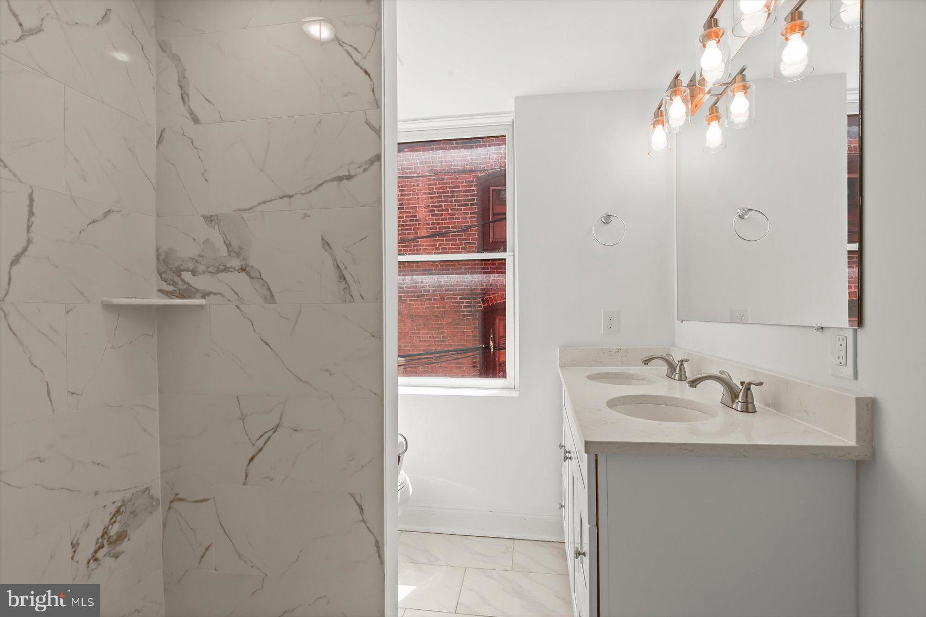 14 East Read Street Baltimore, MD 21202 - Photo 39 of 61 a bathroom with a sink a vanity and a mirror