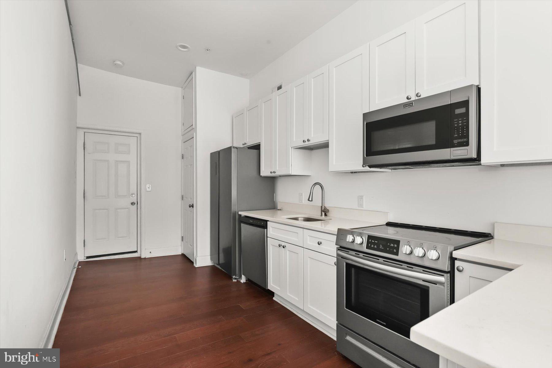 14 East Read Street Baltimore, MD 21202 - Photo 44 of 61 a kitchen with stainless steel appliances a stove microwave and sink