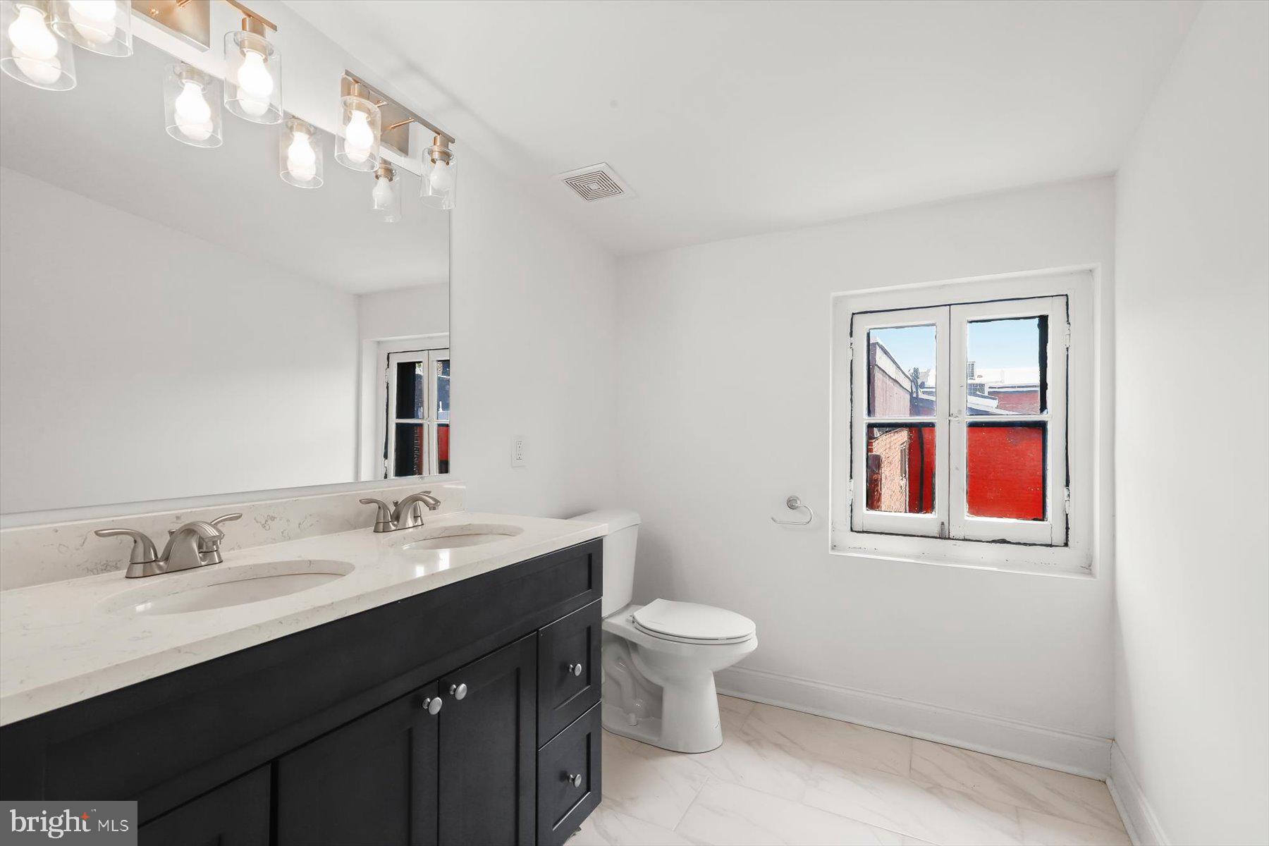 14 East Read Street Baltimore, MD 21202 - Photo 57 of 61 a bathroom with a toilet sink and mirror