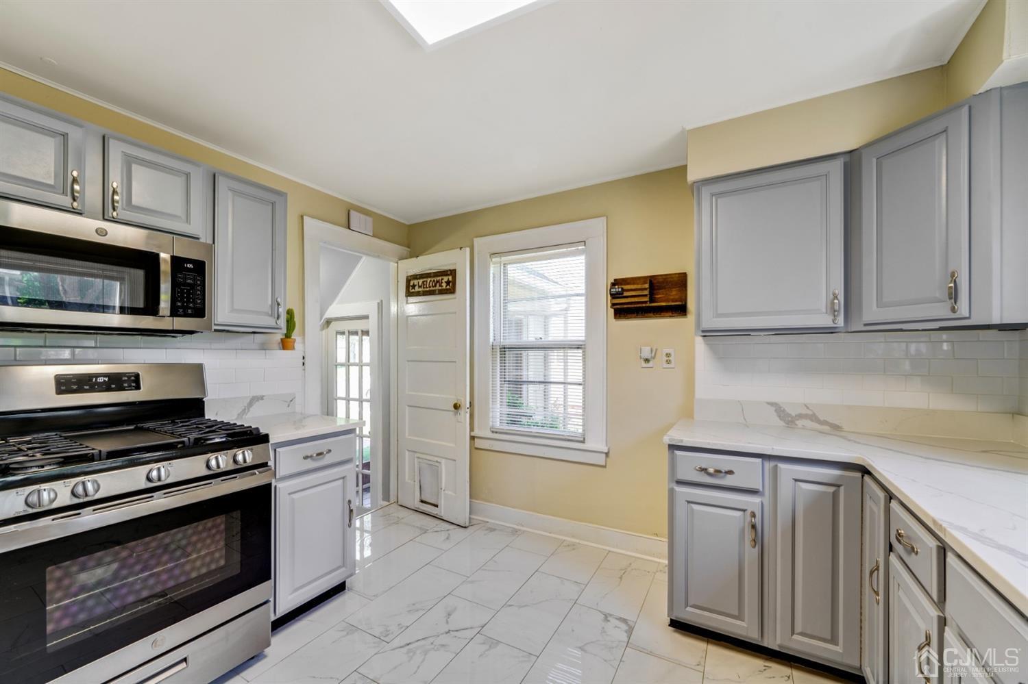 282 Greenbrook Road Plainfield, NJ 07060 - Photo 5 of 15 a kitchen with stainless steel appliances white cabinets and a stove top oven