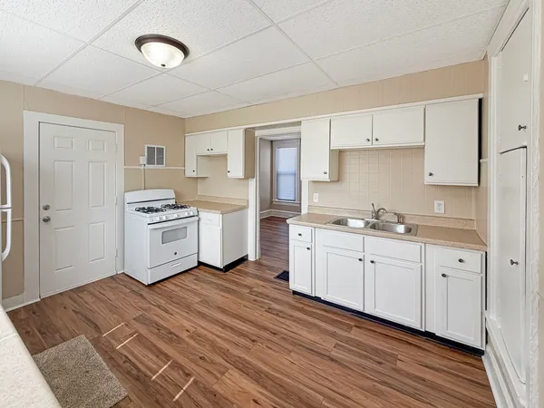 a kitchen with cabinets oven and white appliances