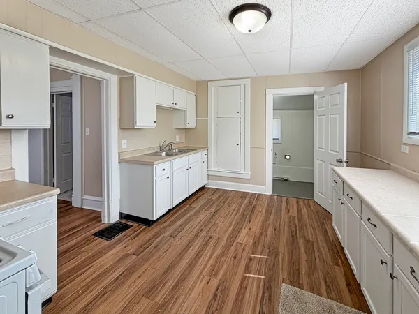a view of a kitchen with cabinets and wooden floor