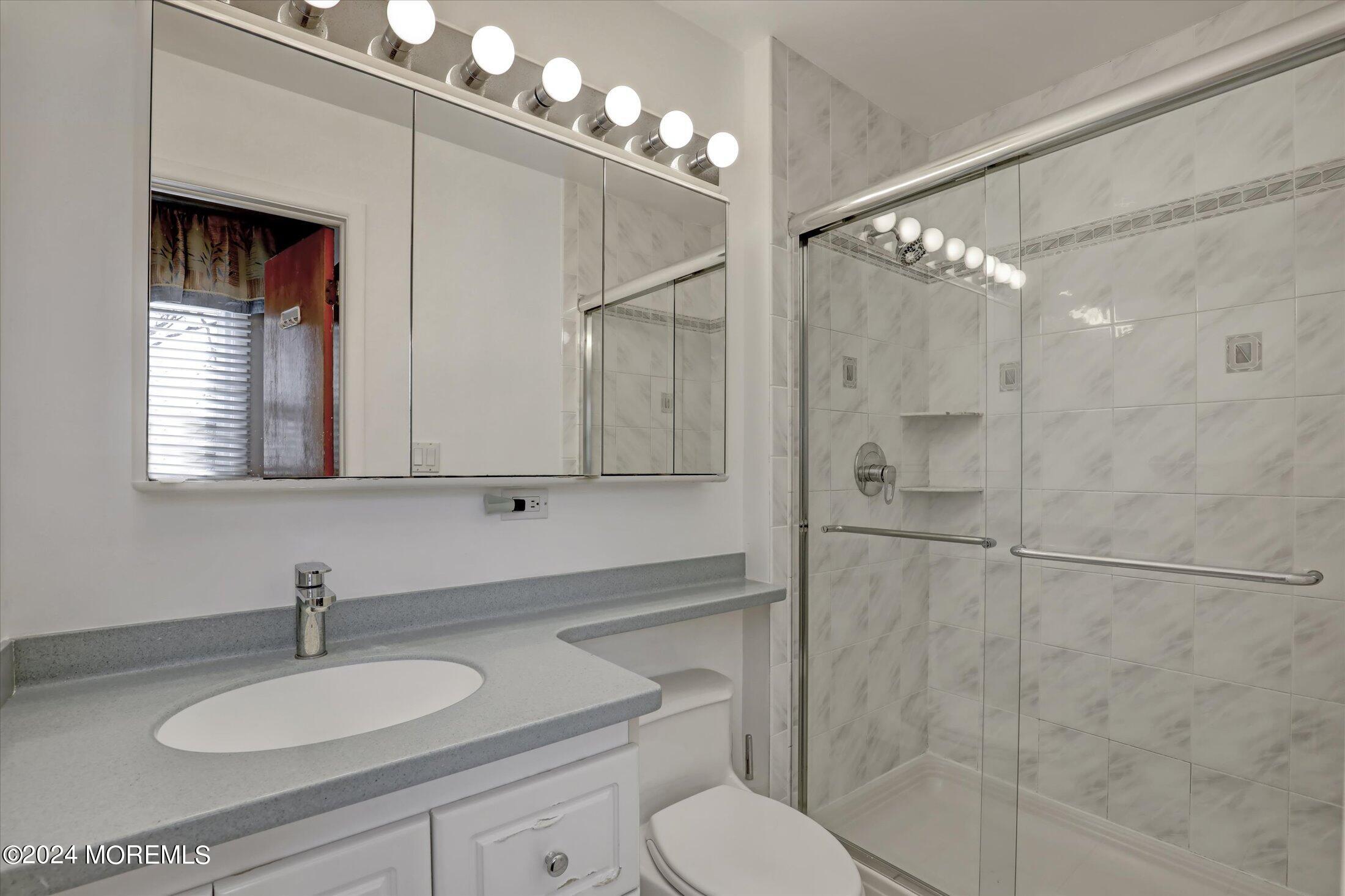 31 Shady Lane Freehold, NJ 07728 - Photo 20 of 40 a bathroom with a granite countertop sink toilet a mirror and shower