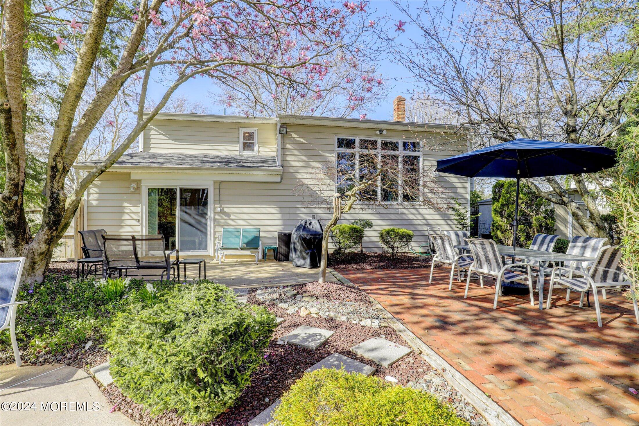 31 Shady Lane Freehold, NJ 07728 - Photo 27 of 40 a view of a patio with table and chairs under an umbrella with large trees
