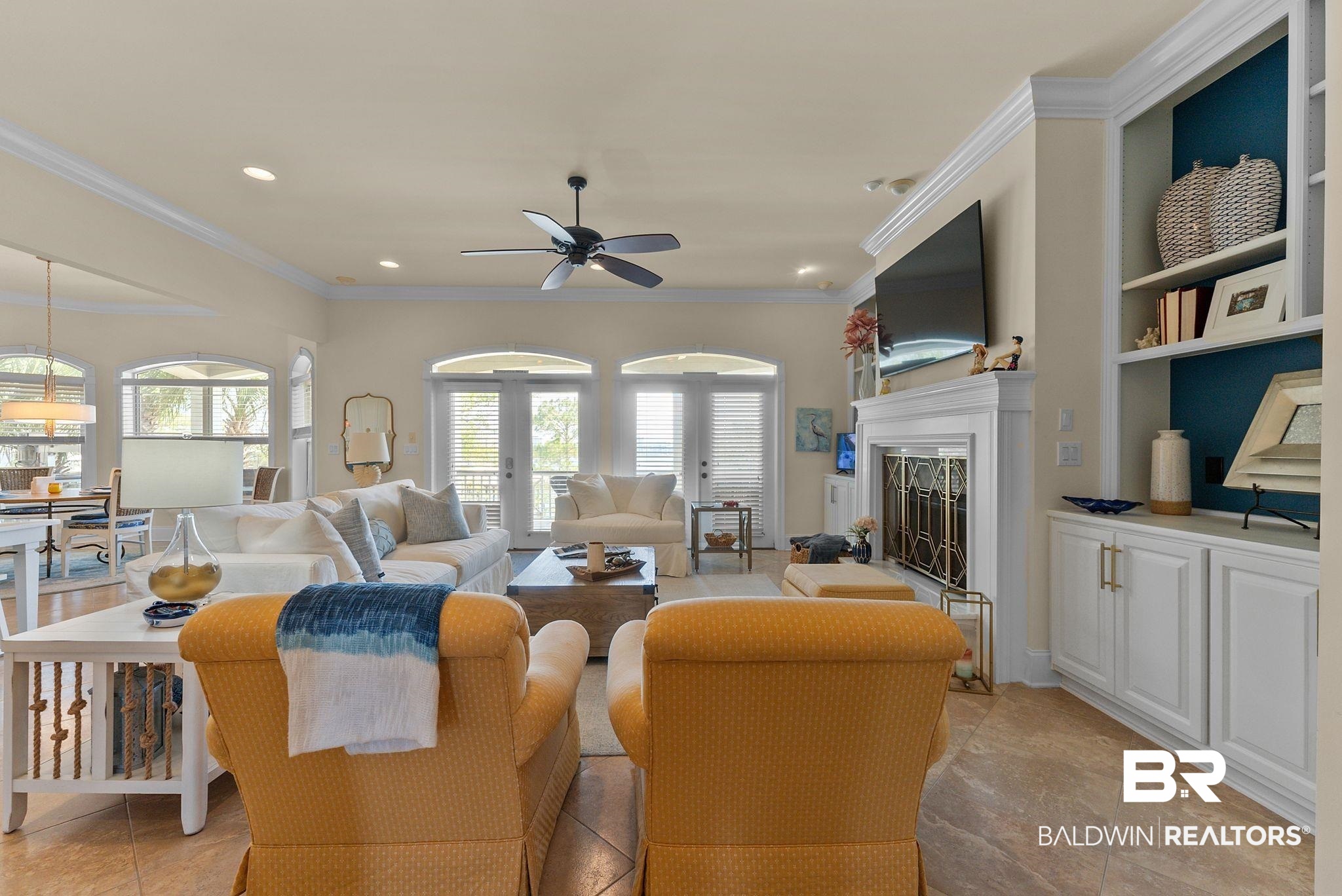 30818 River Road Orange Beach, AL 36561 - Photo 23 of 81 Living area with ceiling fan, built in features, ornamental molding, a fireplace with raised hearth, and recessed lighting