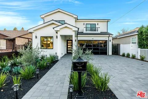 a front view of a house with a garden
