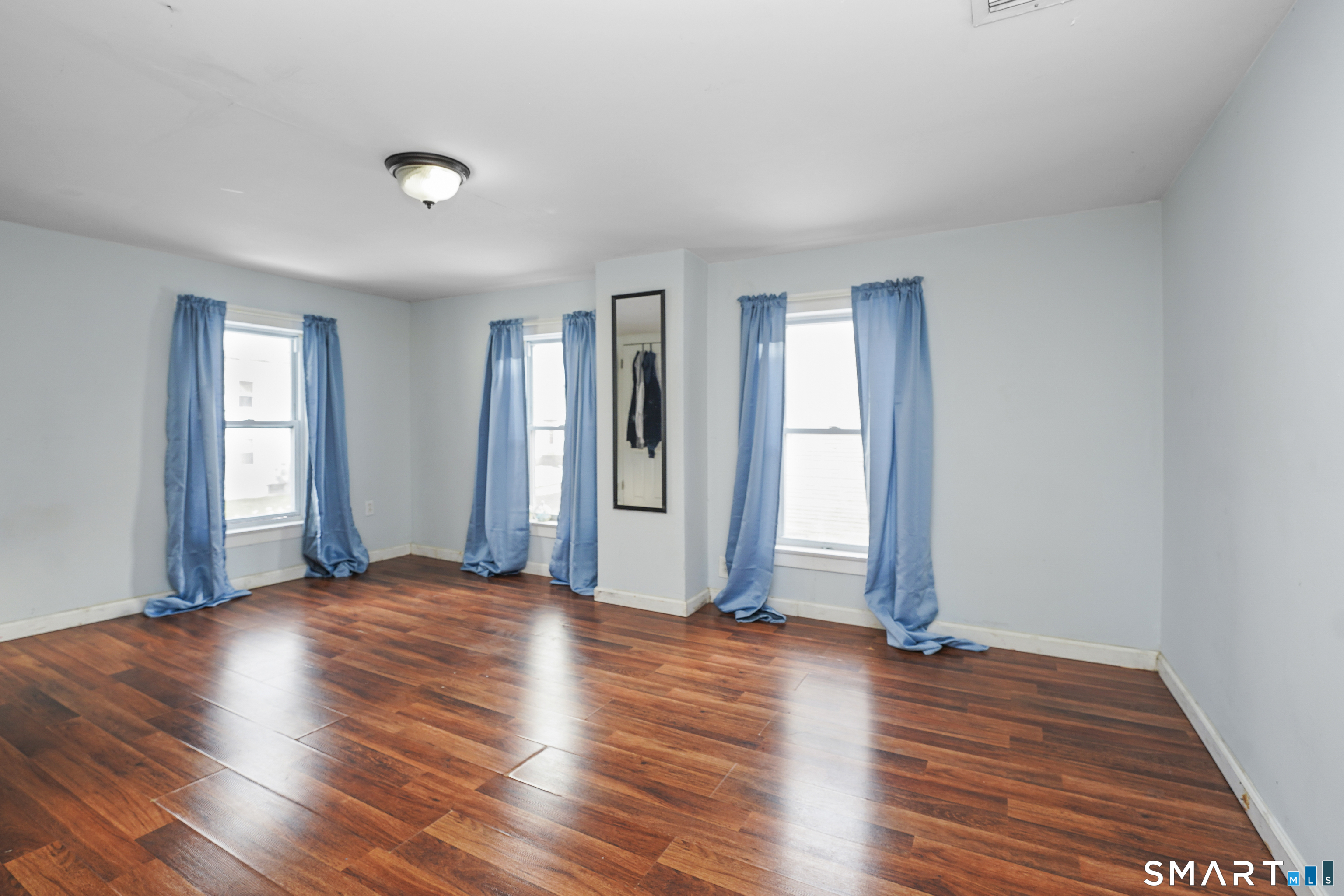17 Windsor Street Enfield, CT 06082 - Photo 16 of 21 an empty room with wooden floor and windows