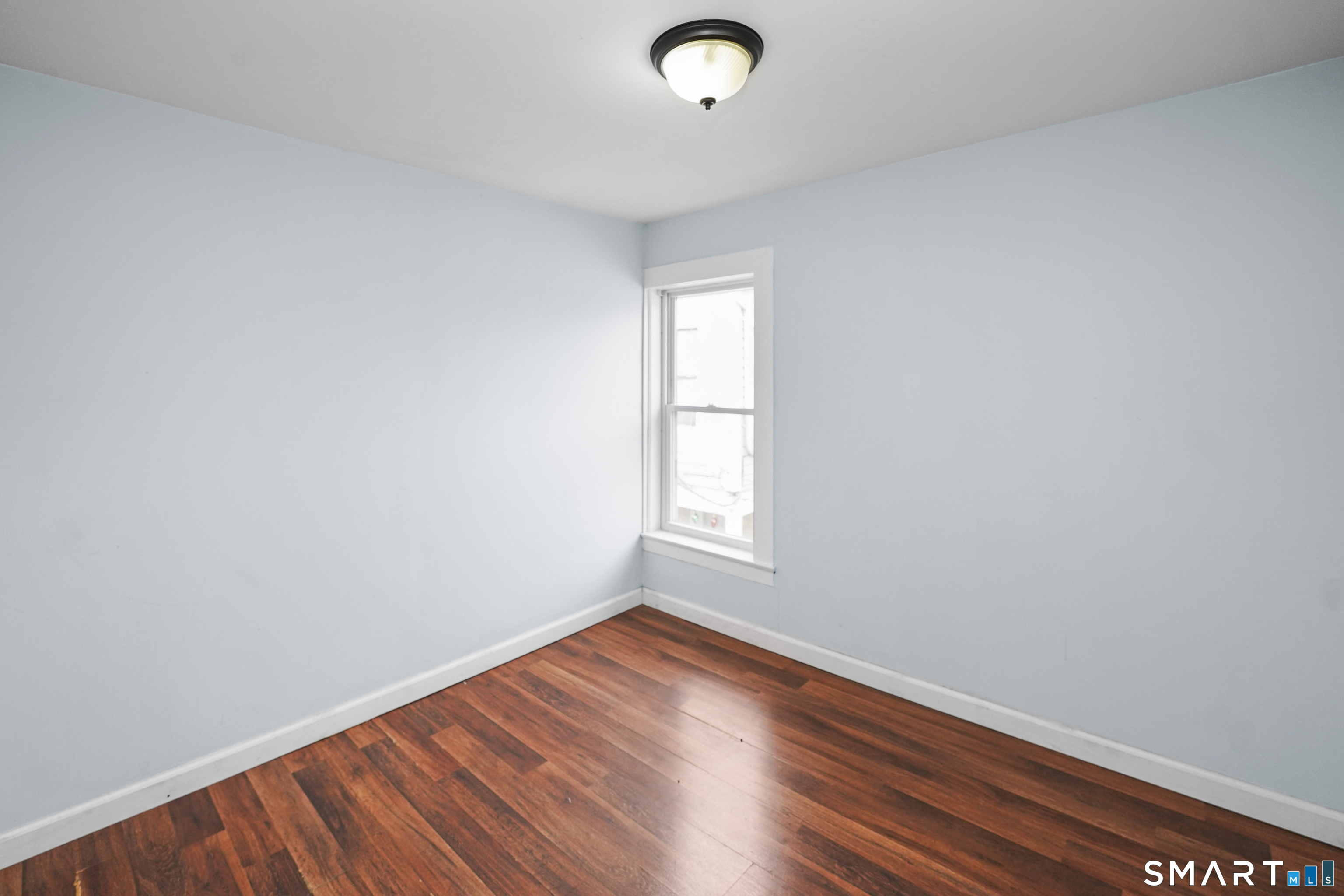 17 Windsor Street Enfield, CT 06082 - Photo 17 of 21 an empty room with wooden floor and windows