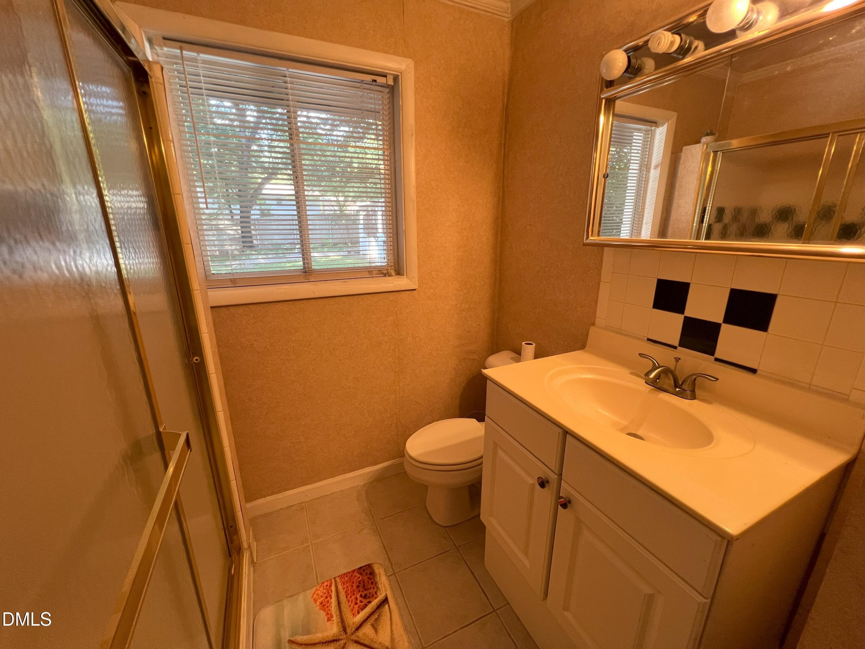 5002 Wickham Road Raleigh, NC 27606 - Photo 27 of 36 a bathroom with a sink and a mirror