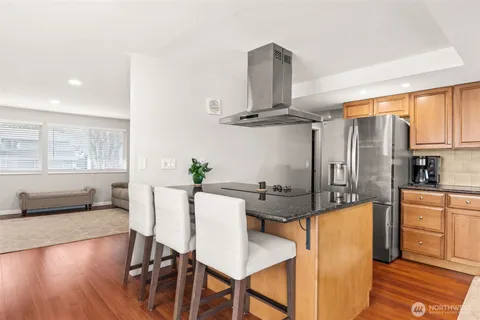 a kitchen with stainless steel appliances a dining table chairs and granite counter tops