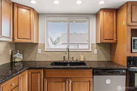 a kitchen with stainless steel appliances granite countertop a sink a stove and a microwave