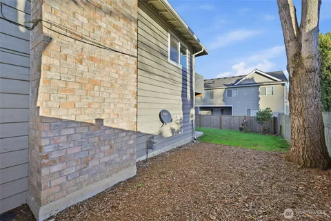 a view of a house with backyard and a tree