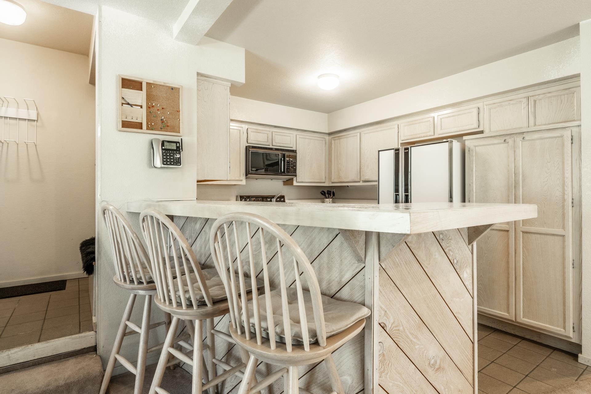 609 Golden Creek Road, Unit 609 Mammoth Lakes, CA 93546 - Photo 28 of 42 Kitchen island with plank wood-finish detailing, integrated breakfast bar, and wood-finish cabinetry