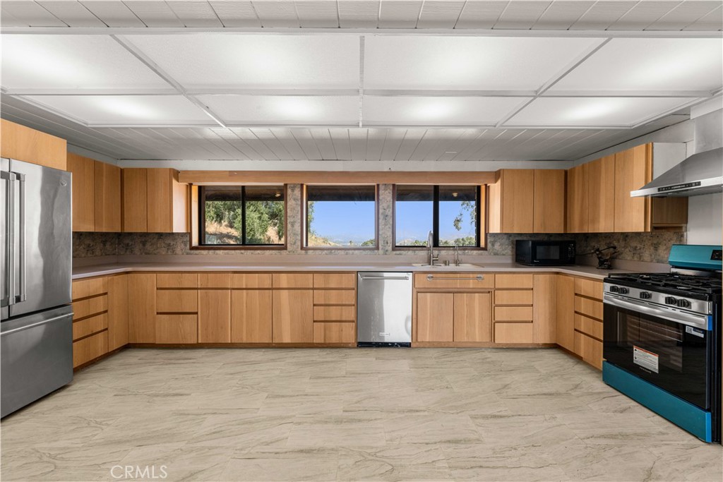 6308 Hawarden Drive Riverside, CA 92506 - Photo 10 of 37 a large kitchen with stainless steel appliances granite countertop a stove a sink dishwasher and a refrigerator
