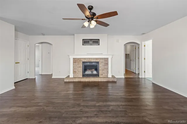 a view of an empty room with exposed radiator and fireplace