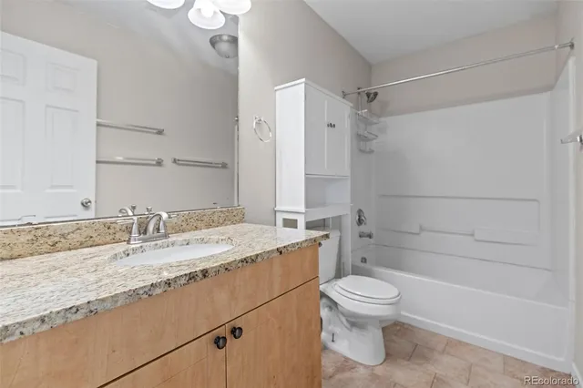 a bathroom with a granite countertop sink toilet a mirror and shower